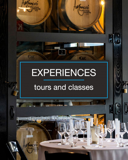 Experiences -tours and classes Experiences -tours and classes white text on a black box with a dining table full of glasses and wine barrels in background